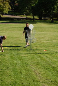 Men Close to the Basket Playing Disc Golf