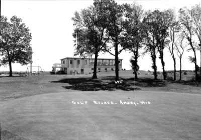 A building in the background of a group of trees 