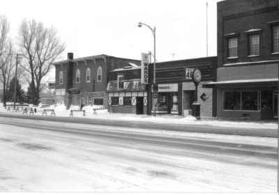 A black and white photo of a row of historical businesses