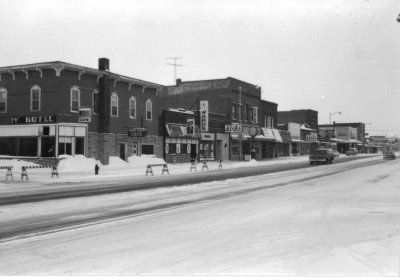 A black and white photo of a row of historical businesses