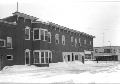 A black and white photo of a historic building after a snow storm